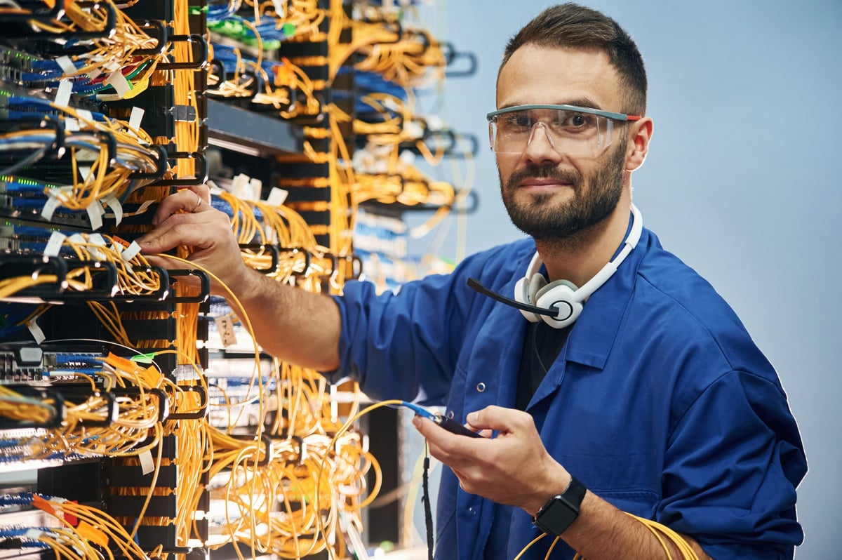 Technician checking signal and wiring on internet equipment