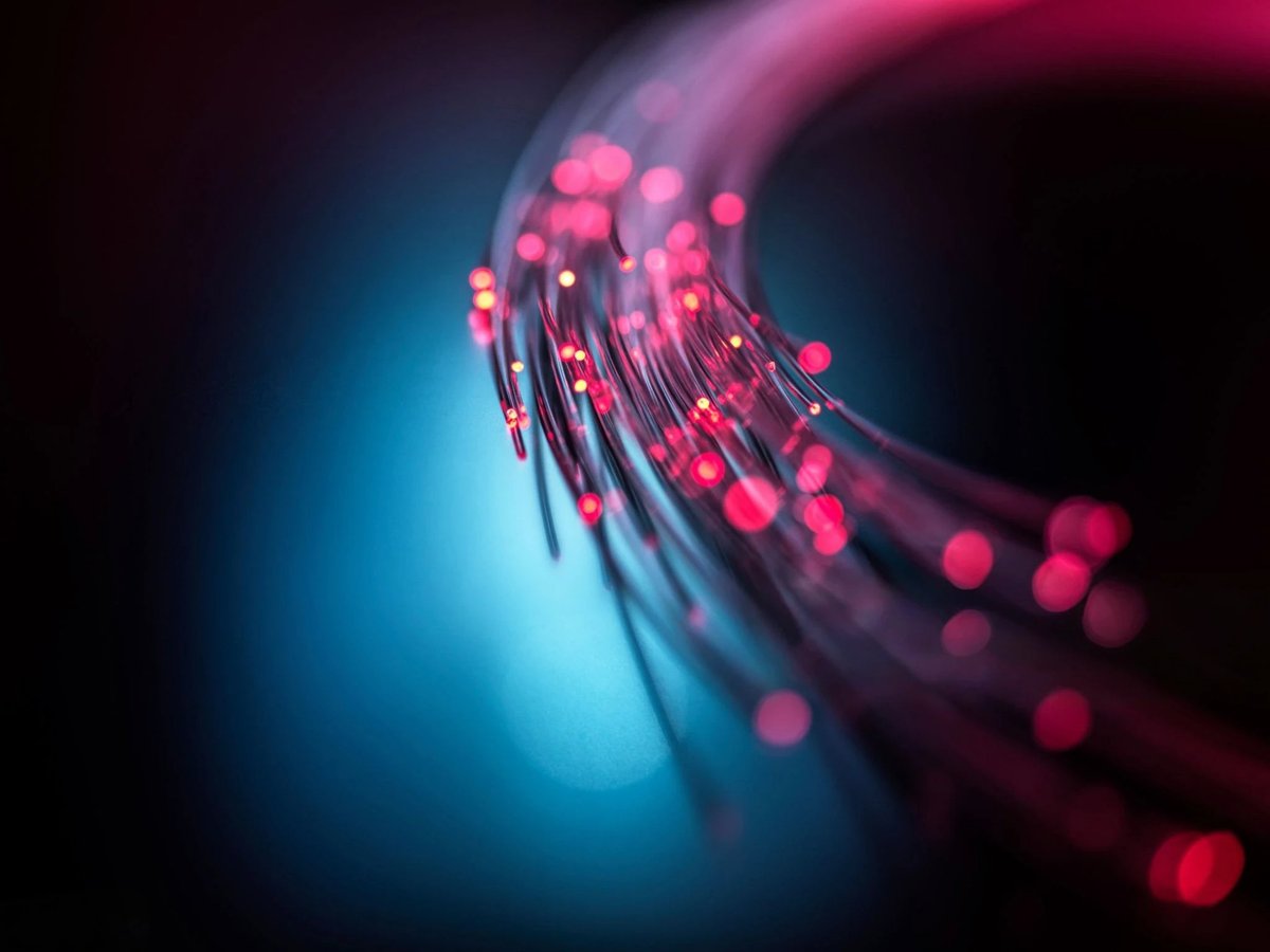 Close-up of illuminated fiber optic cables representing high-speed data transmission
