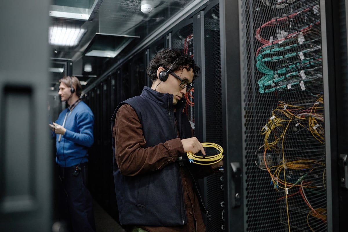 Technicians working with network cables in a server room