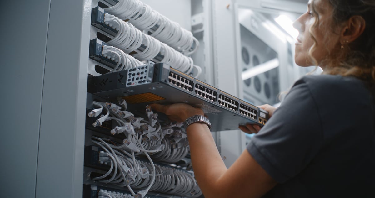 ALYAFTECH network technician installing active switch hardware in a server rack