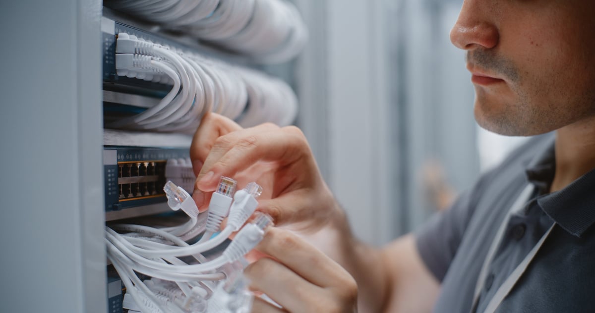 Data center technician checking structured cabling connections and patch cords